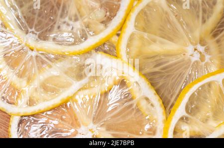 Lemon thin slices filling the entire space, stacked on top of each other. Refreshing citrus in close-up. Lemon, citrus background. Stock Photo