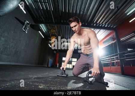 Strong determined male athlete doing strength workout Stock Photo