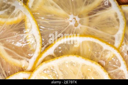 Lemon thin slices filling the entire space, stacked on top of each other. Refreshing citrus in close-up. Lemon, citrus background. Stock Photo