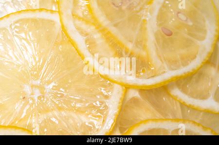 Lemon thin slices filling the entire space, stacked on top of each other. Refreshing citrus in close-up. Lemon, citrus background. Stock Photo