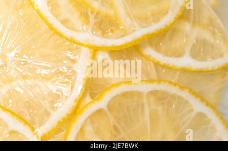 Lemon thin slices filling the entire space, stacked on top of each other. Refreshing citrus in close-up. Lemon, citrus background. Stock Photo