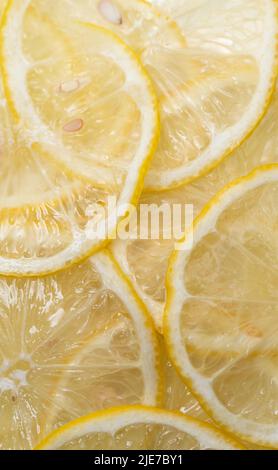 Lemon thin slices filling the entire space, stacked on top of each other. Refreshing citrus in close-up. Lemon, citrus background. Stock Photo