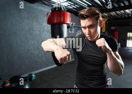 Focused young athlete shadowboxing during gym workout Stock Photo
