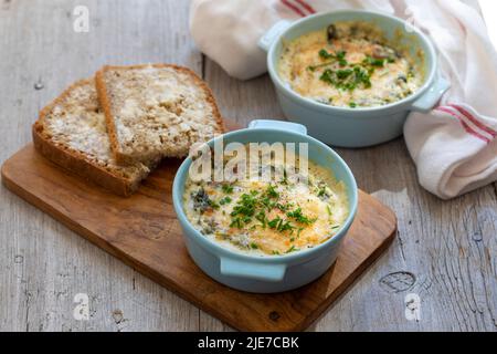 Egg baked in spinach and bechamel sauce Stock Photo