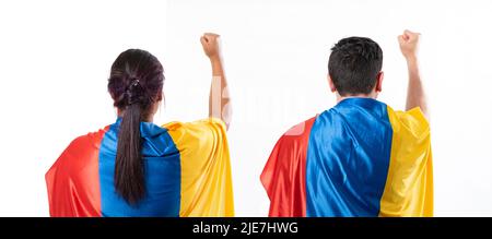 A woman and a man turning their backs, dressed in the Colombian flag and with their hands raised in protest Stock Photo