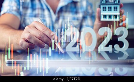 Hand write on tablet and touch screen. Stock market 2023 concept. businessman trader looking at chart analysis candle Stock Photo