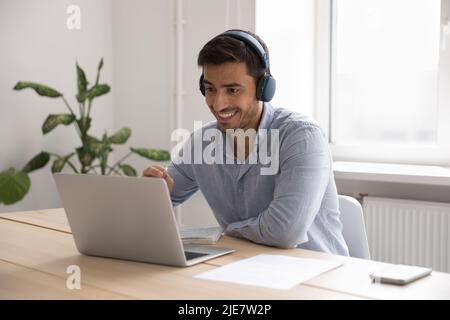 Businessman in headphones working on-line use laptop in office Stock Photo
