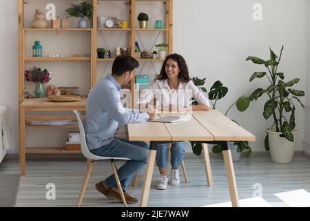 HR manager interviewing young Hispanic female during meeting in office Stock Photo