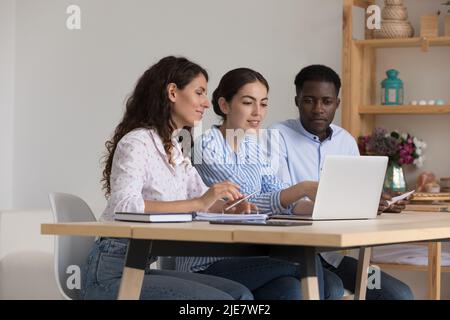 Three multi ethnic employees learning corporate software using laptop Stock Photo