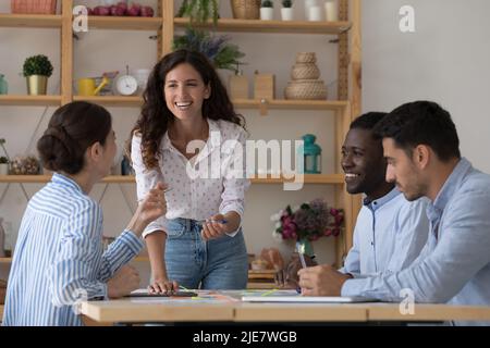Four multi ethnic staff cooperate, working gathered together in office Stock Photo