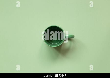 Empty mug cup on green background. top view, copy space Stock Photo