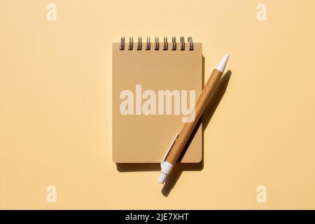 Notebook and pen on beige background. top view, copy space Stock Photo