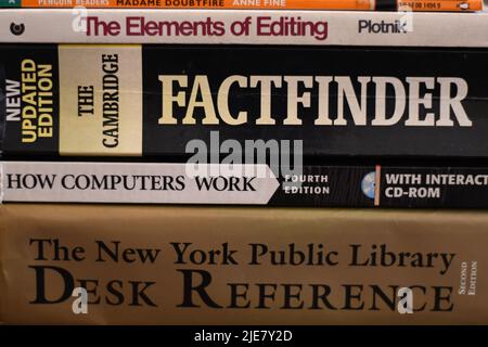 Side view of a pile of knowledgeable books on a table Stock Photo
