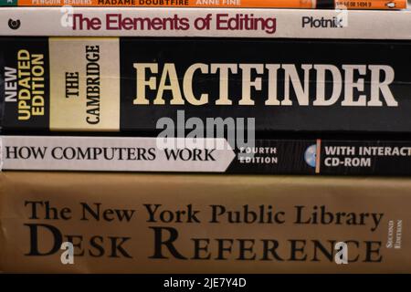 Side view of a pile of knowledgeable books on a table Stock Photo