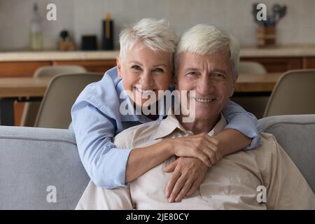 Older wife piggyback husband smiling looking posing for camera Stock Photo