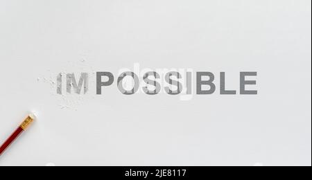 Changing word impossible to possible with pencil eraser. Eraser of pencil rubbing on impossible wording to possible on white paper for positive thinki Stock Photo