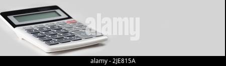 close up white calculator on gray background for business financial concept. crop image of calculator. copy space. wide banner Stock Photo