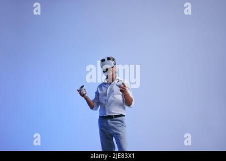 business meeting in the metaverse. Senior businessman giving a presentation using virtual reality technology. Mature businessman communicating with hi Stock Photo