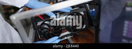 Man mechanic installing cooler fan with copper tubes on computer processor Stock Photo