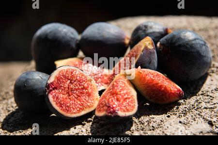 Figs cut into pieces lie on a stone. High quality photo Stock Photo