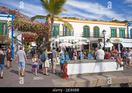 Restaurants and bars at the harbour promenade, flower decoration on arches in the alleys of Puerto de Mogan, Gran Canaria, Canary islands, Spain Stock Photo