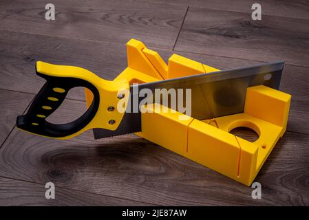 Construction tool - miter saw with miter box on a laminate floor. Stock Photo