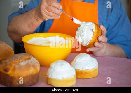 one grandmother smears Easter cake with protein cream Stock Photo