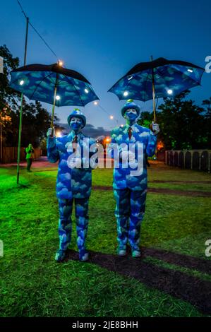 Glastonbury, UK. 25th June, 2022. Performers dressed as a Magritte Painting entertain people in the evening - The 50th 2022 Glastonbury Festival, Worthy Farm. Glastonbury, Credit: Guy Bell/Alamy Live News Stock Photo