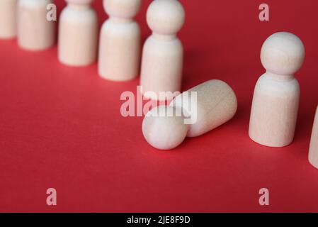 Wooden doll fall out of row line. Moral and physical exhaustion, stress, burnout at work concept. Stock Photo