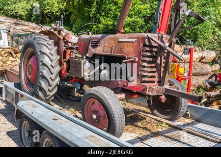 Old American McCormick tractor on trailer - France. Stock Photo