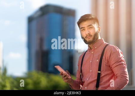 Elegant asian businessman using a mobile outdoors Stock Photo