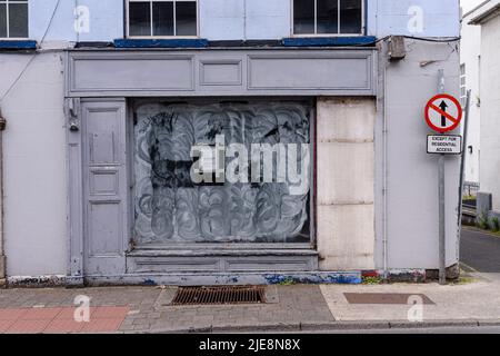 Shop with a boarded up door and whitewashed window after going out of business.  Republic of Ireland. Stock Photo