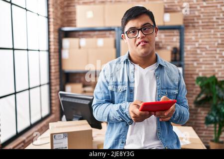 Down syndrome man ecommerce business worker using touchpad at office Stock Photo