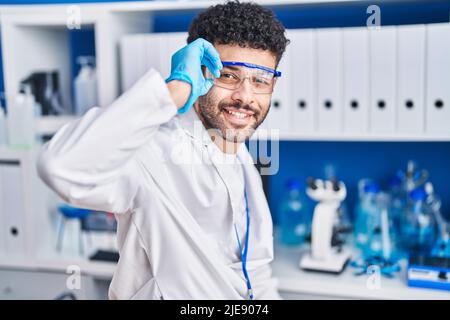 Young arab man wearing scientist uniform smiling confident at laboratory Stock Photo