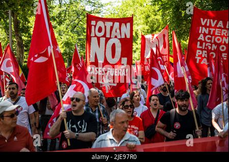 Madrid, Spain. 26th June, 2022. People carrying banners during a demonstration against NATO. Spain will host a NATO Summit in Madrid on 29 and 30th of June 2022. Credit: Marcos del Mazo/Alamy Live News