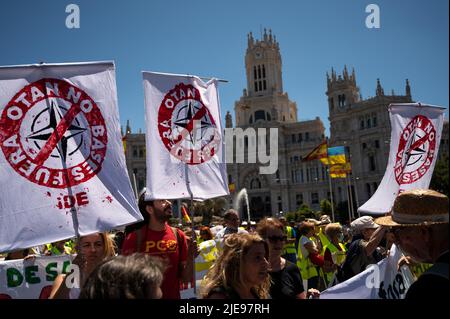 Madrid, Spain. 26th June, 2022. People carrying banners during a demonstration against NATO. Spain will host a NATO Summit in Madrid on 29 and 30th of June 2022. Credit: Marcos del Mazo/Alamy Live News Stock Photo