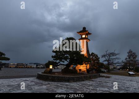 Matsue, Shimane, JAPAN - Dec 1 2021 : Illuminated Aoyagirou-no-daitourou (or ootourou, Aoyagirou’s big lantern) at Shirakata Park at stormy evening. Stock Photo