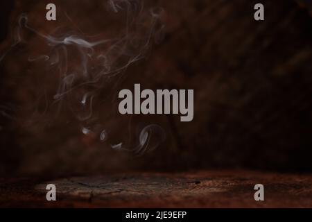 Old wood table top with smoke in dark background. Stock Photo