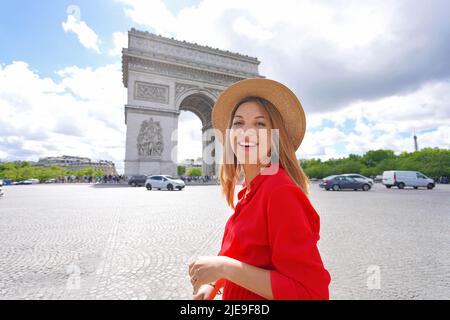 Portrait of young fashion woman walking in Paris with Arc de Triomphe, France Stock Photo