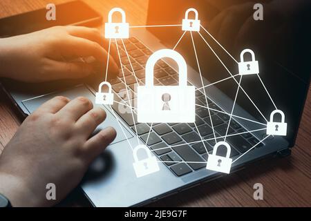 Woman hands typing on laptop with warm light and lock protection interface. Internet security and data protection concept. Stock Photo