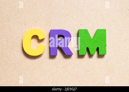 Color alphabet letter in word CRM (Abbreviation of Customer Relationship Management) on wood background Stock Photo