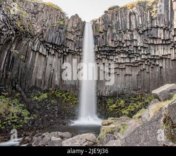 Svartifoss waterfall in Skaftafell National Park in Iceland, surrounded by dark basalt columns Stock Photo