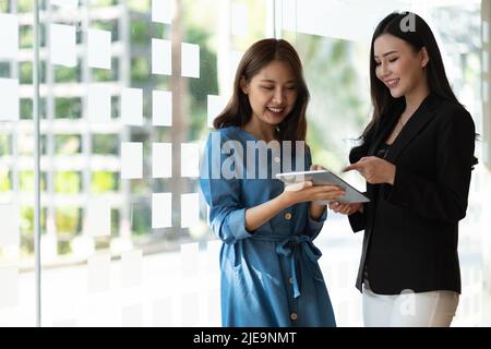 Business partnership coworkers using a tablet to analysis graph company financial budget report and cost work progress and planning for future in Stock Photo