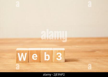 web3 characters. Written on four wooden blocks. White letters. Wooden table background. Stock Photo