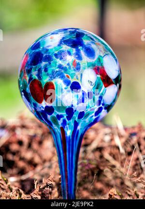 Blown Glass Water Container closeup in plant.  Shades of blue glass. Stock Photo