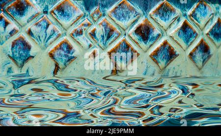 Abstract aqua blue diamond shape pattern with its reflection in water Stock Photo