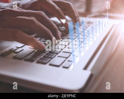 Close up hand Businessman touch enter on laptop keyboard show graph stock market bar chart grow up to target. Business finance concept Businessman ana Stock Photo