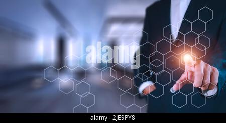 Businessman pressing button on hologram virtual screens with hexagons and transparent. Business technology internet and virtual reality concept. Stock Photo