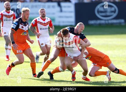 Catalans Dragons' Tom Davies (centre) is tackled during the Betfred Super League match at the Mend-A-Hose Jungle, Castleford. Picture date: Sunday June 26, 2022. Stock Photo