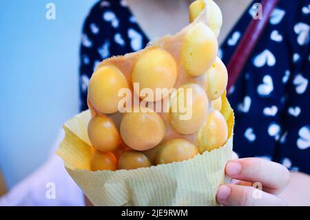 A hand holding the Hong Kong Egg Puffs (Eggette/ Waffles) . Stock Photo